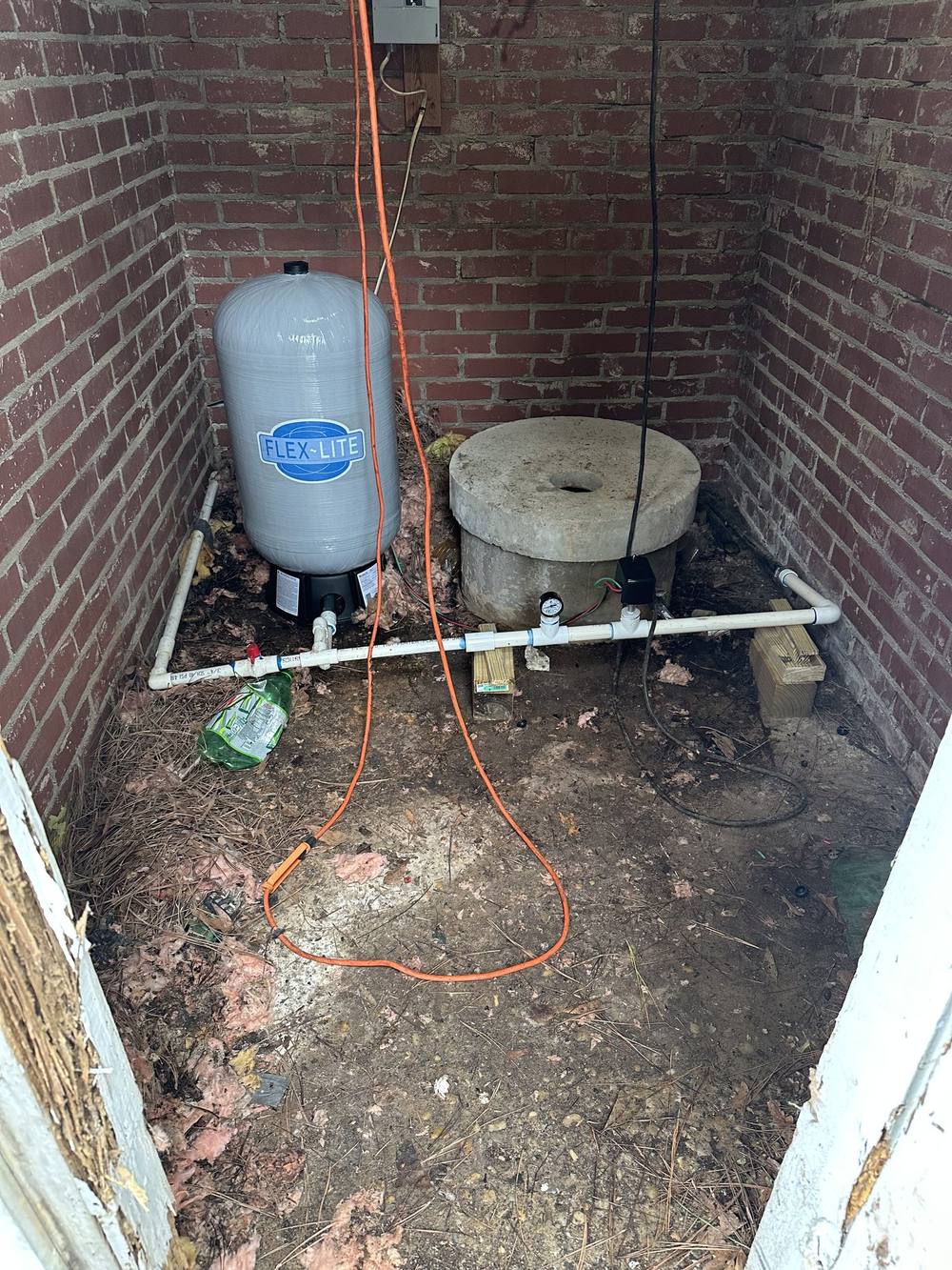 Pressure tank and well cap inside a brick pump house